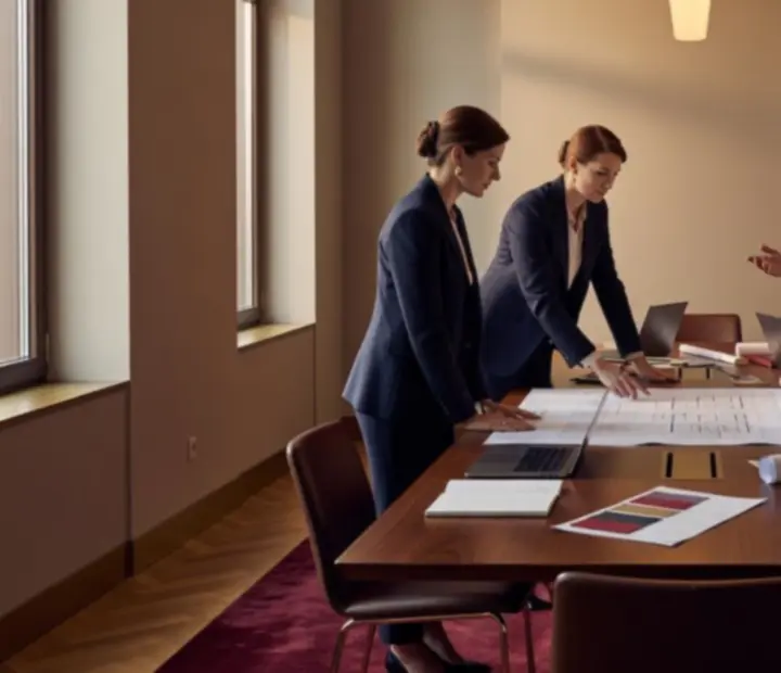 Zespół planujący przebieg eleganckiego wydarzenia przy planach i laptopach